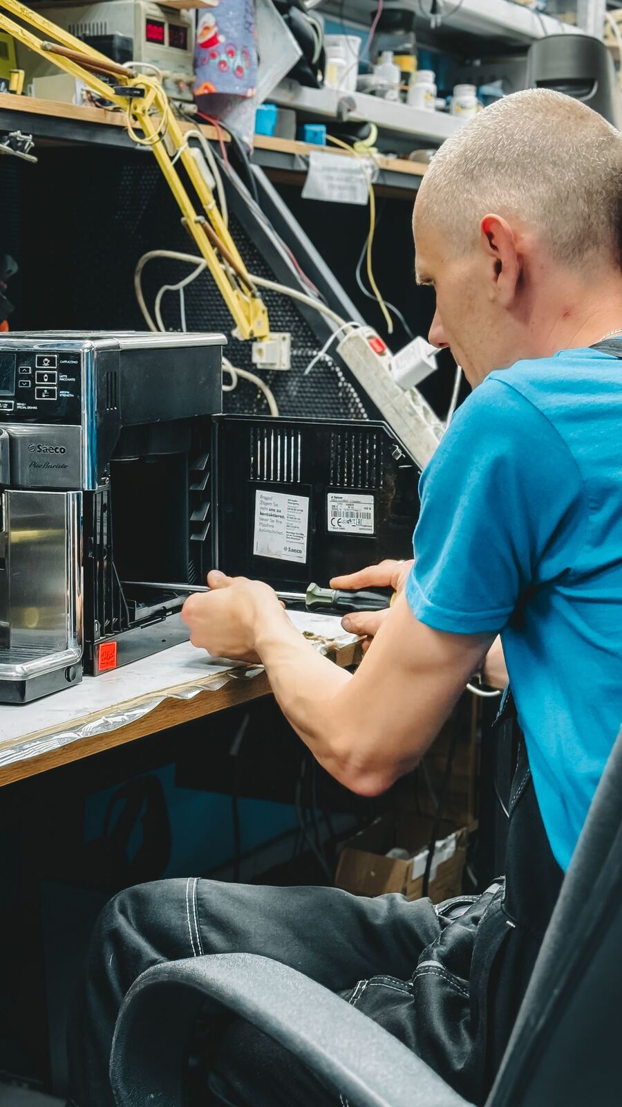 Technician removing the side panel of a bean-to-cup coffee machine