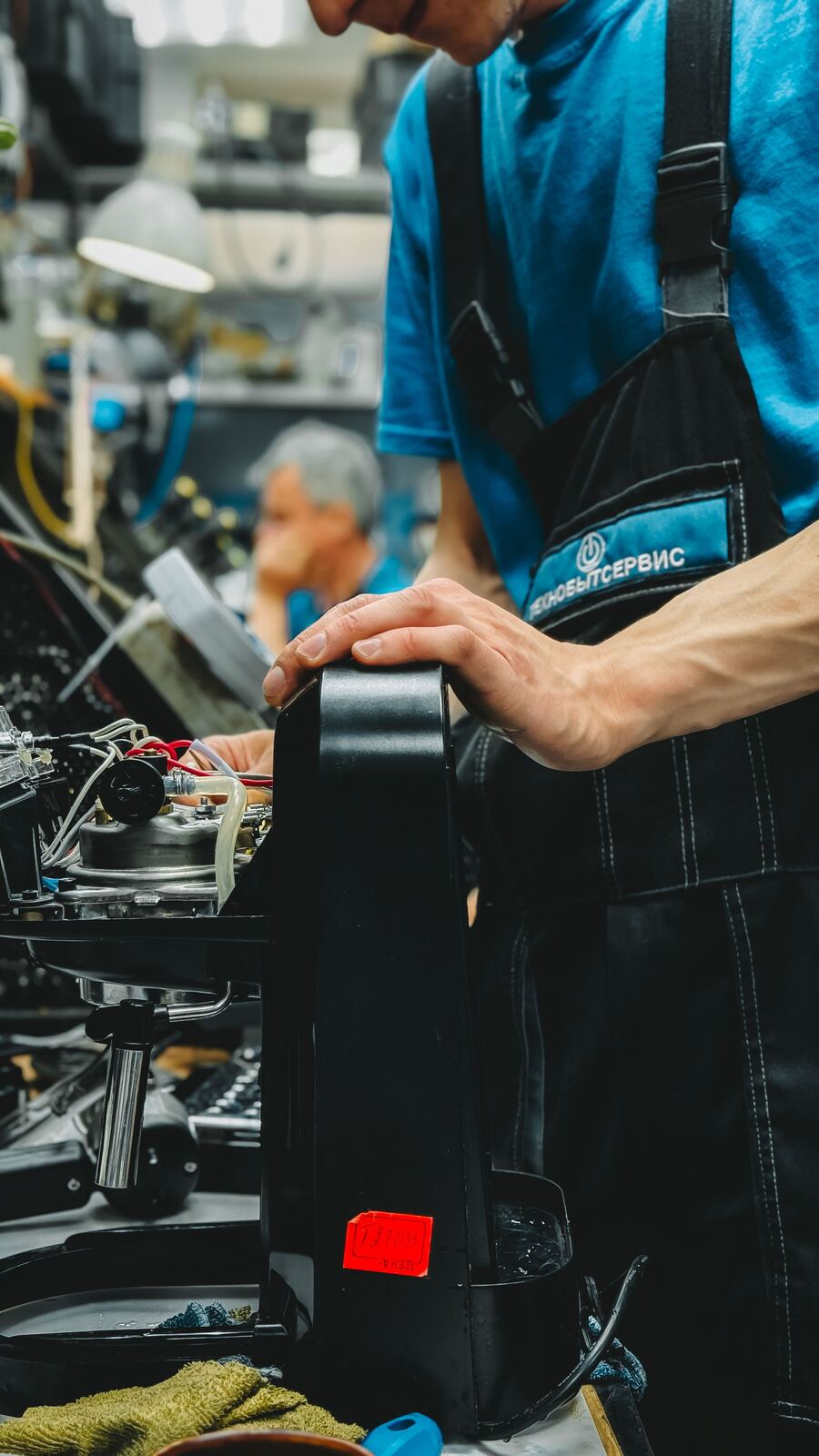 Technician checking the internal boiler and wiring of an espresso machine